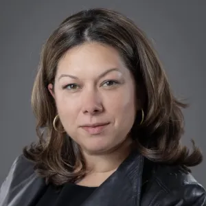 portrait photo woman with medium length brown hair wearing a black leather blazer