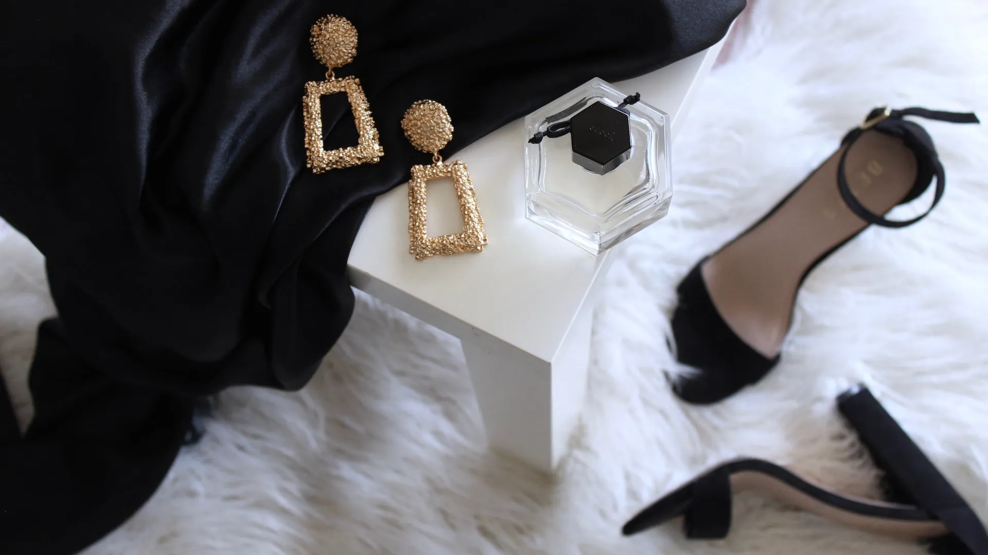 Top view of women clothing accessories on a white fluffy carpet